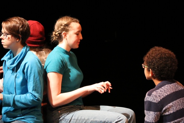 youth sit pretending to type at a computer.