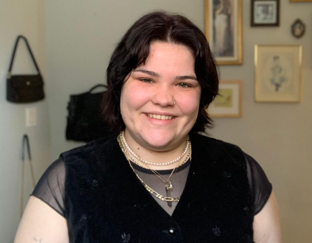 Rachel smiles at the camera wearing a black top